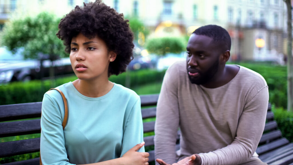 young couple arguing, woman angrily looking off in the distance.