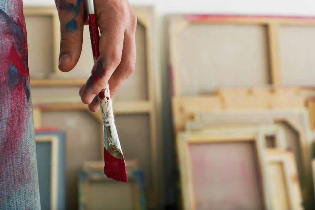 person holding paintbrush feeling energized after painting