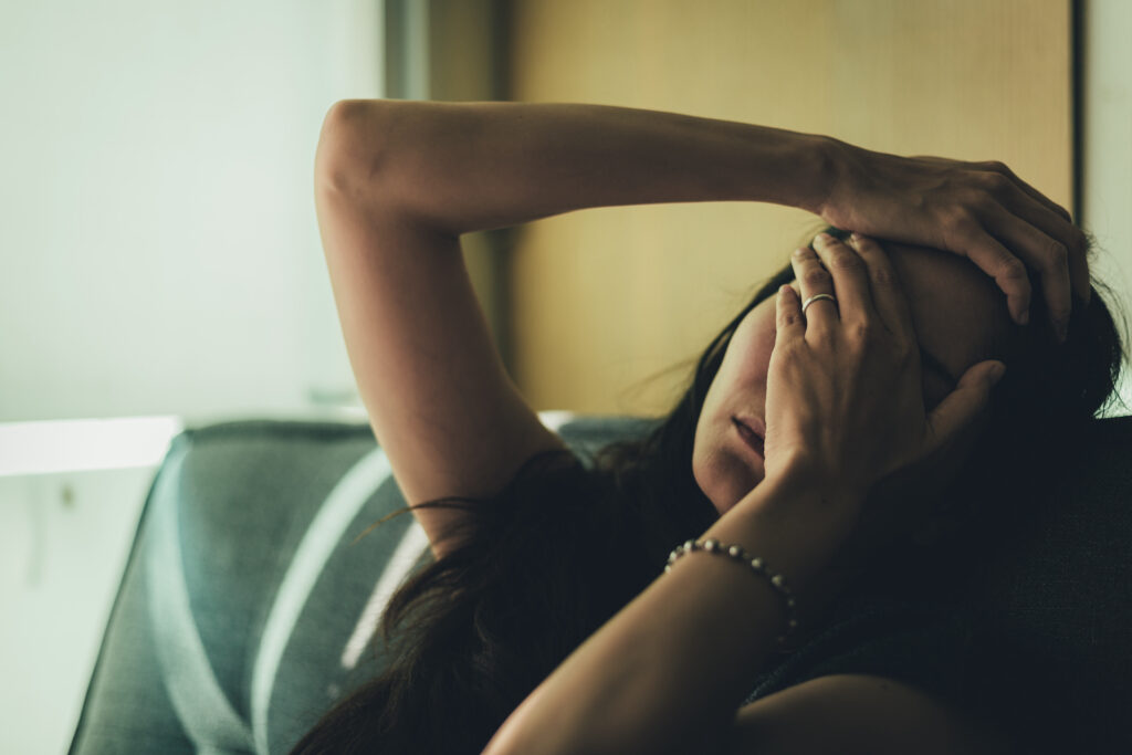 Women holding hand over face feeling drained of energy