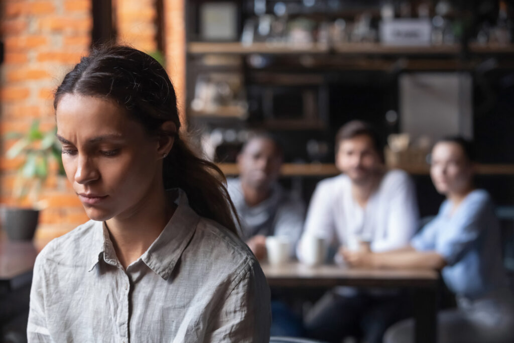 woman isolated feeling shame and stigma from those behind her