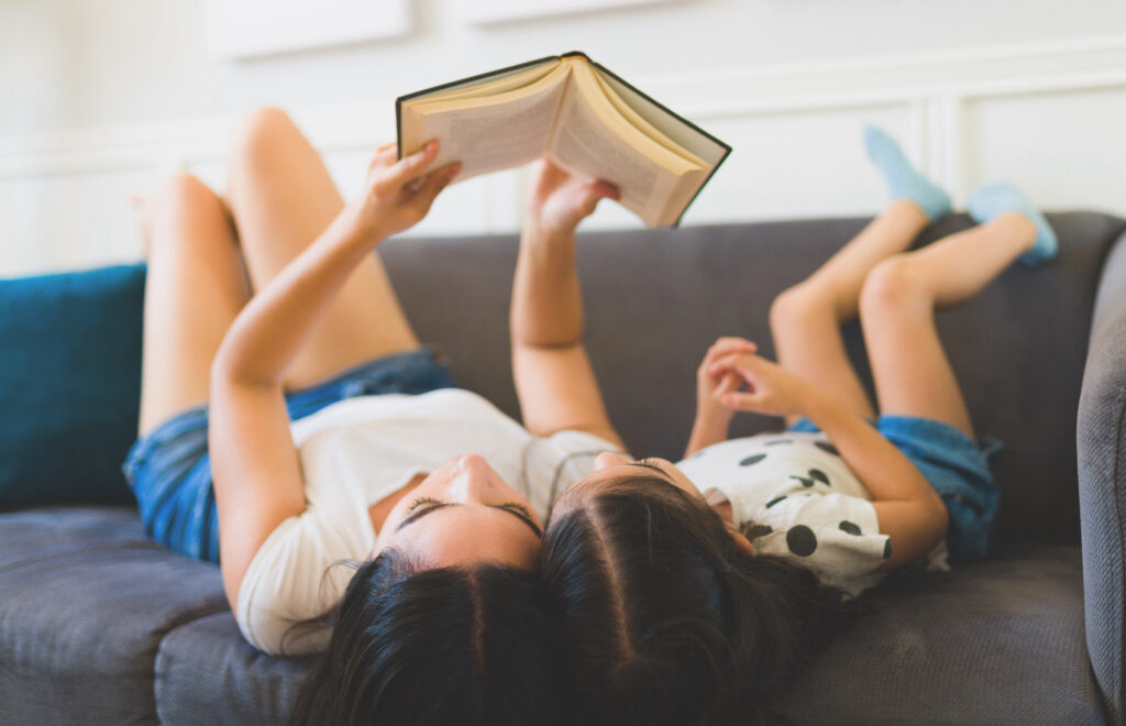mother and daughter reading on the couch
