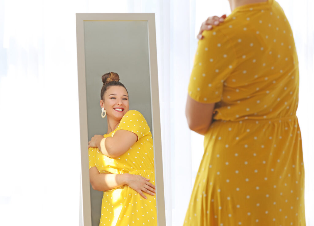 woman looking in the mirror with self-love