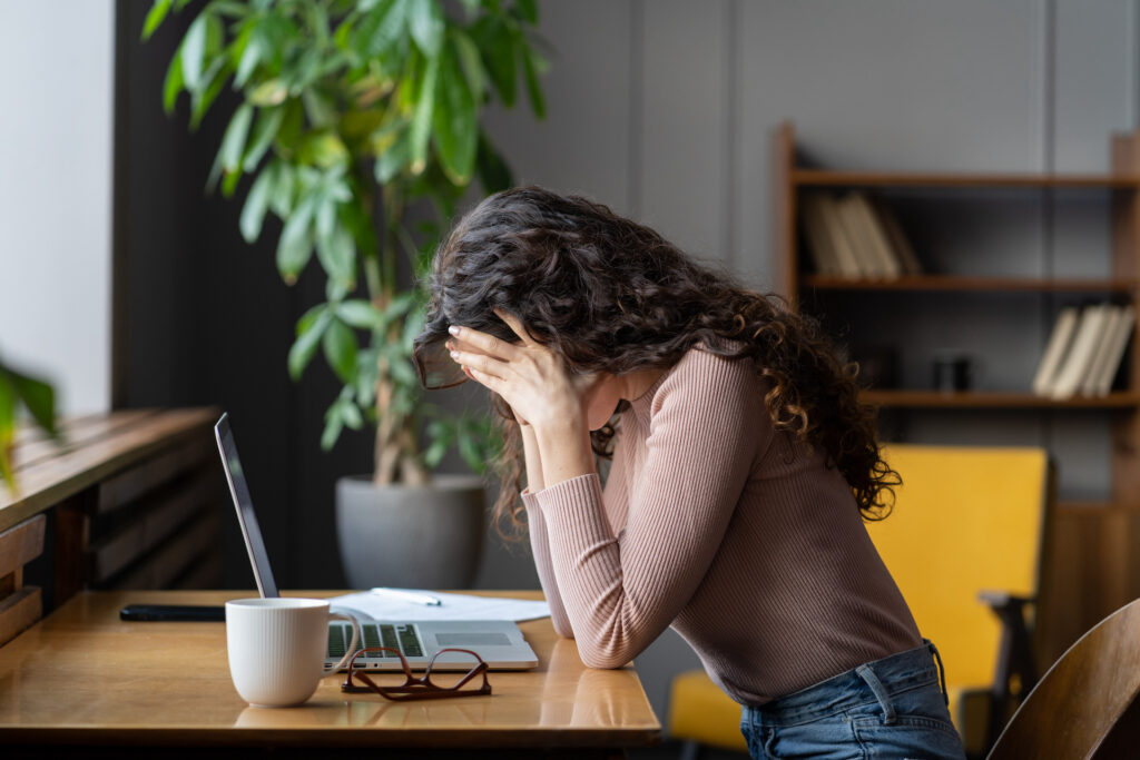 women sitting at computer head in heads stressed 