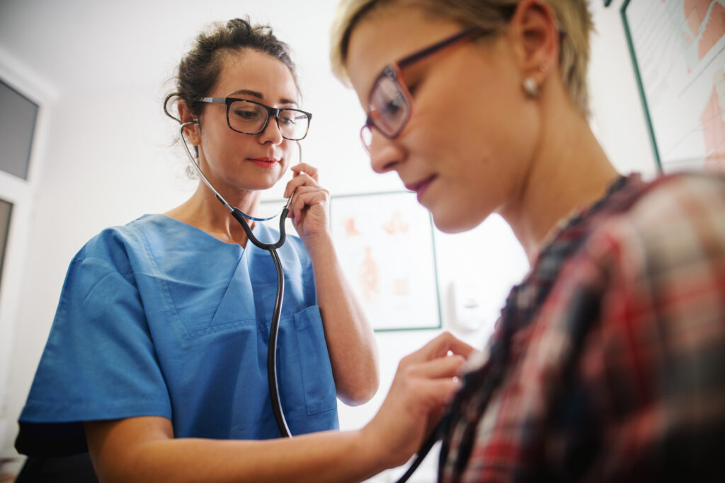 doctor listening to heartbeat of patient 