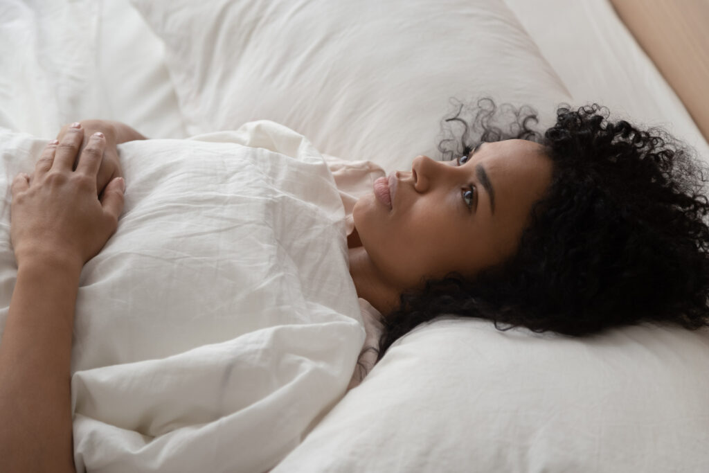 woman lying in bed restless during silent retreat