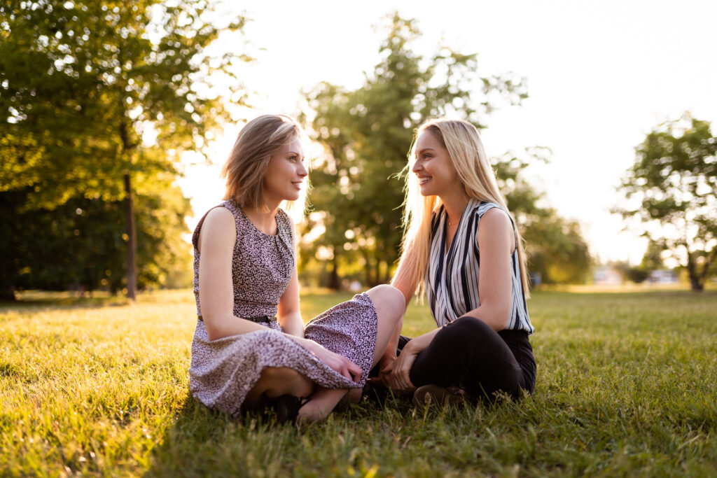 two friends sitting in a park talking about stress