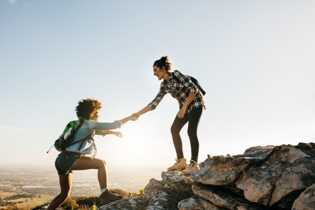 two women trusting each other on a hike