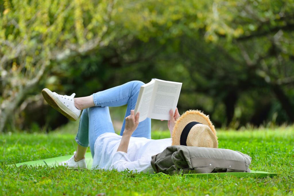 woman reading in park feeling stress-free