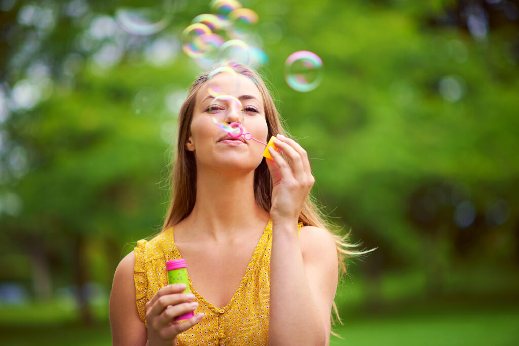 woman blowing bubbles embracing inner child