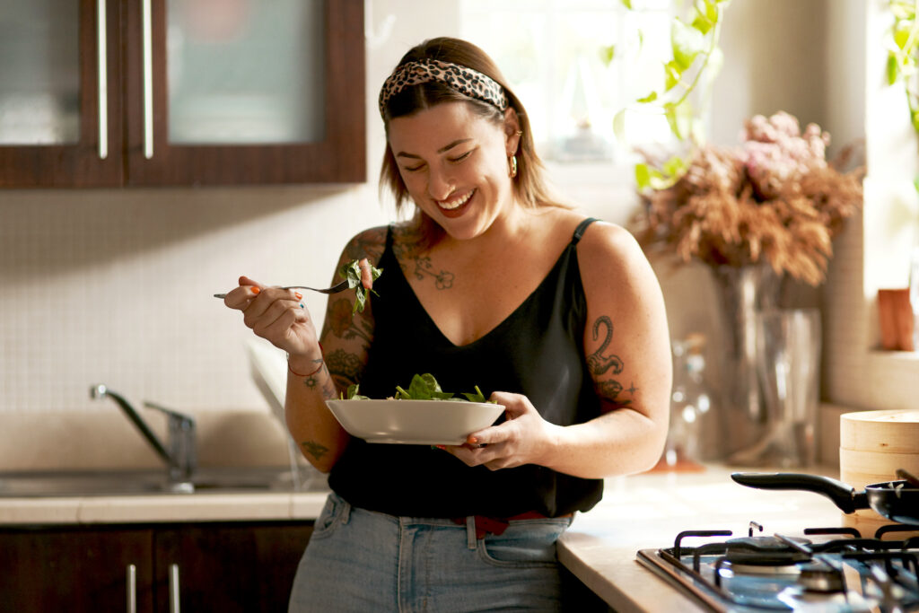 woman eating in kitchen